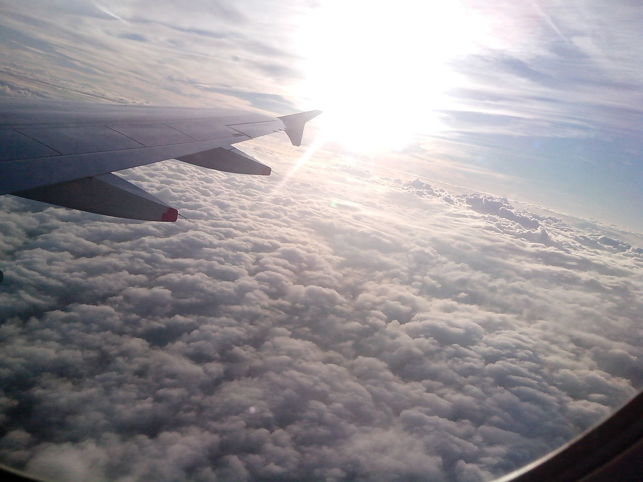 airplane, cloud - sky, sky, aircraft wing, transportation, air vehicle, sun, sunlight, mode of transport, sunbeam, cloudy, part of, cloud, low angle view, cropped, nature, travel, no people, day, flying