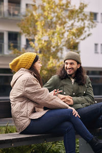 Man and woman talking on bench