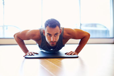 A man doing a push up in a gym.