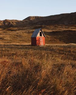 Lifeguard hut on field against clear sky