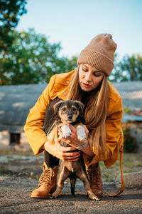 Pet love. volunteer woman plays with homeless puppies in the autumn park. authentic moments of joy