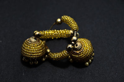 Close-up of gold colored pencils on table against black background