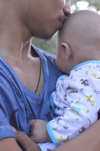 Midsection of father with baby hands