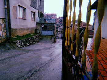 Street amidst houses against buildings in city