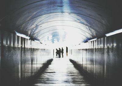 People walking in illuminated tunnel