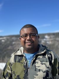 Portrait of young man standing against sky