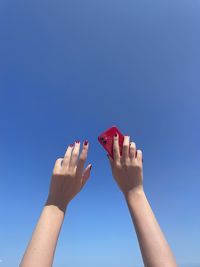 Red iphone red nails and clear sky hands up