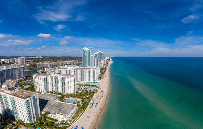 Aerial view of swimming pool by buildings against sky