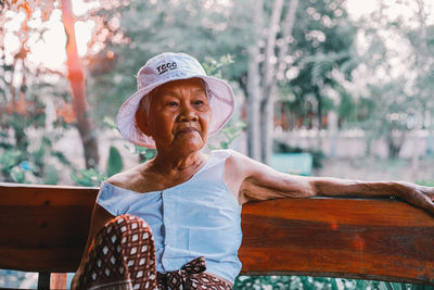 Portrait of woman wearing hat sitting outdoors