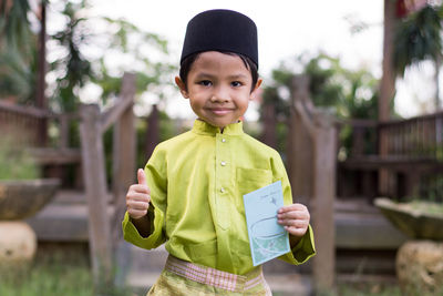 Portrait of cute boy in traditional clothing holding envelop