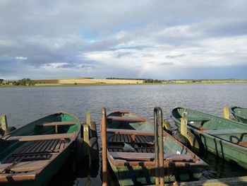 Boats moored in lake against sky