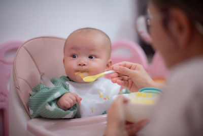 Close-up of boy eating food at home