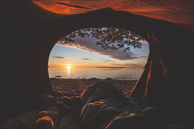 Scenic view of sea against sky during sunset seen through tent