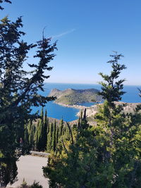 Scenic view of sea and mountains against clear blue sky