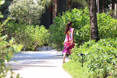 Young woman standing by plants