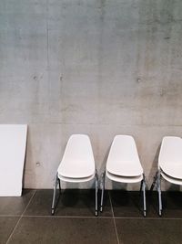 Empty chairs against wall