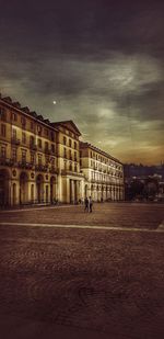 People walking on street against buildings in city