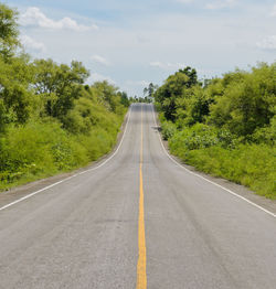 Road amidst trees against sky