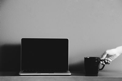 Close-up of man using laptop on table