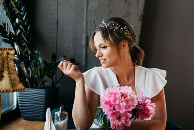 Young woman sitting on table at home