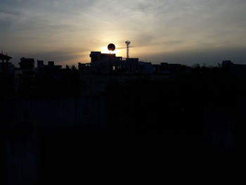 Silhouette of buildings against sky during sunset