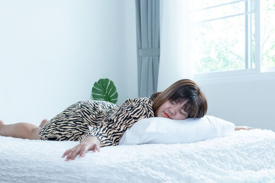 Woman lying on bed at home