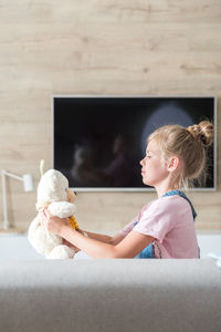 Side view of girl playing with toy