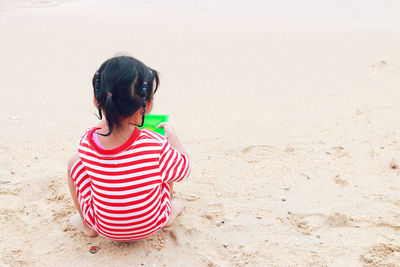 Rear view of girl playing at beach