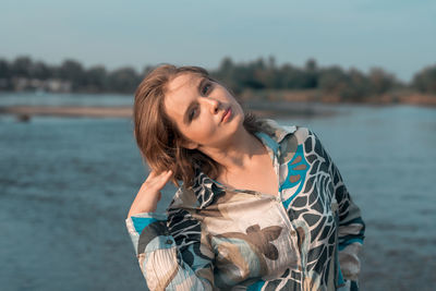 Portrait of young woman standing in water