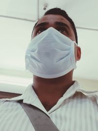 Low angle view of man wearing flu mask