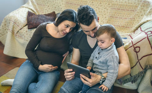 Young woman using mobile phone while sitting on sofa at home