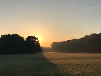 Scenic view of field against sky during sunset