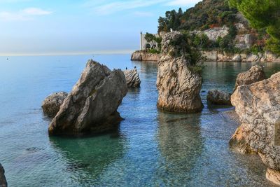 Rock formation in sea against sky