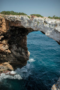 Rock formations by sea against sky