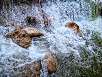 High angle view of water flowing through rocks