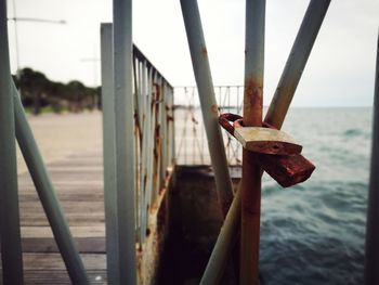 Close-up of bridge over sea against sky