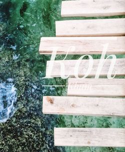 High angle view of text on bench by lake