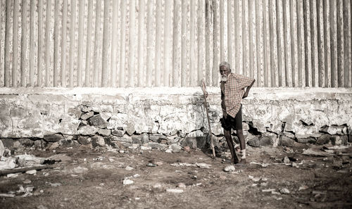 Full length of man standing on field against wall