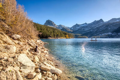 Scenic view of lake and mountains against blue sky