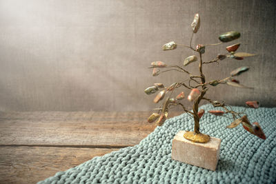 Jasper and wire tree in the rays of light on knitted fabric and old vintage wooden background