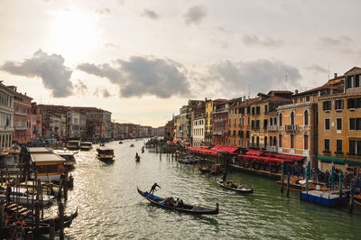 Boats moored in city against sky