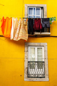 Clothes drying against yellow building