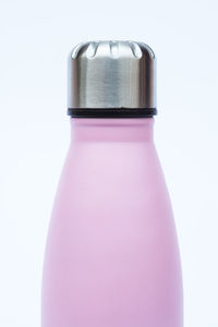 Close-up of pink bottle against white background