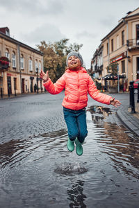 Full length of woman with umbrella in rain