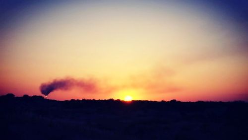 Scenic view of silhouette landscape against sky at sunset