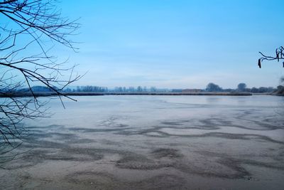 Scenic view of lake against sky during winter