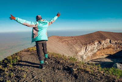 Rear view of a hiker at the volcanic crater - the ash pit on mount ol doinyo lengai , tanzania