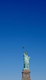 Low angle view of statue against blue sky