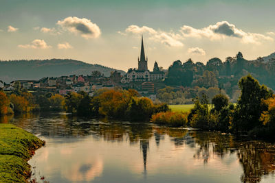 Scenic view of lake by buildings against sky