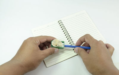 Midsection of person reading book against white background